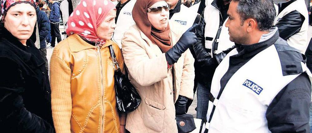 Angespannte Lage. Frauen diskutieren bei einer Demonstration in Tunis mit einem Polizisten. Foto: Haikal Hmima/dpa