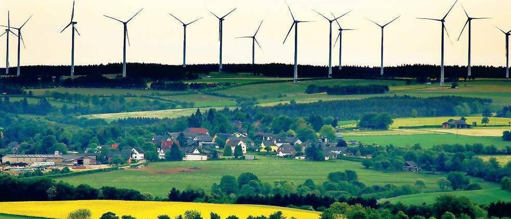 Teamarbeit. Ein Rapsfeld zur Agrarspritproduktion vor einem Windpark in der Eifel. Beiden traut der Weltklimarat eine bedeutende Rolle im künftigen Energiesystem zu. 