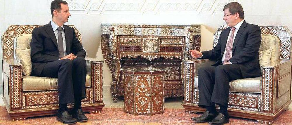 Angespannt ist inzwischen das Verhältnis der einstigen Freunde Syrien und Türkei. Auch das Treffen zwischen Präsident Baschar al Assad (links) und Ankaras Außenminister Ahmet Davutoglu in Damaskus verlief am Dienstag augenscheinlich nicht in lockerer Atmosphäre. 