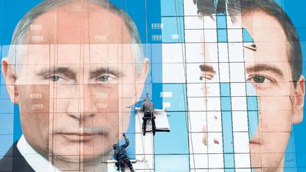 Putin bleibt – sein Rivale Medwedew (rechts) bleibt Episode: Plakatekleben im südrussischen Krasnodar. 