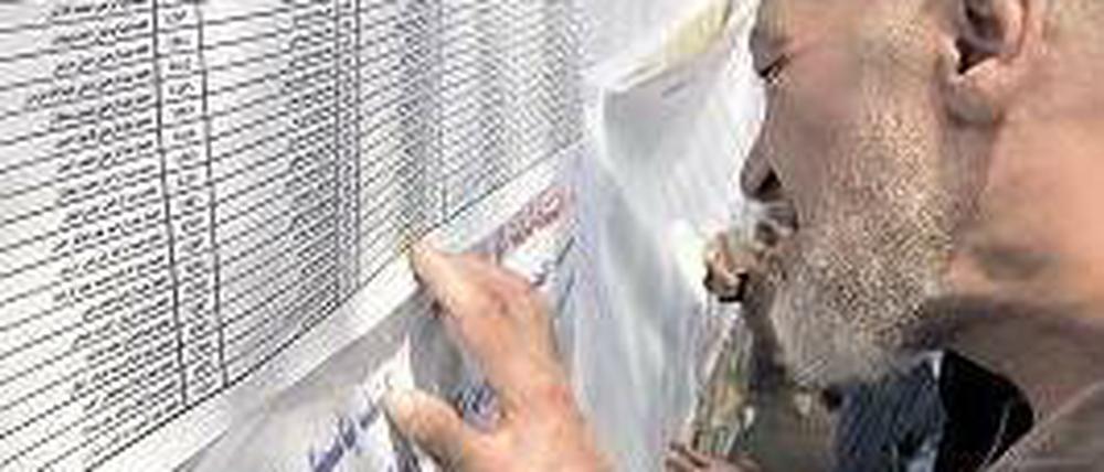 Ein Wähler sucht auf einer Liste vor einem Wahllokal nach seinem Namen. Foto: AFP