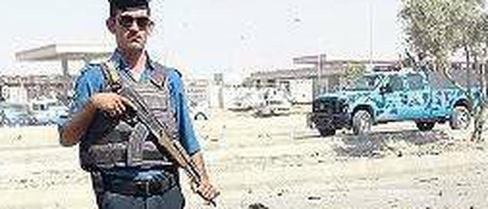 Einer von vielen Anschlägen: Im nordirakischen Kirkuk bewacht am Montag ein Polizeibeamter den Tatort nach einer Autobombenattacke.