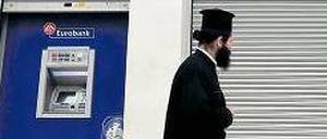 Knapp bei Kasse. Ein griechisch-orthodoxer Priester geht an einer Bankfiliale vorbei, die wegen eines Streiks der Angestellten geschlossen ist.