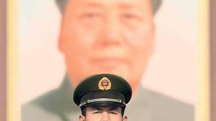 Ein Wächter steht am Tag der Entscheidung vor einem Porträt Mao Tse-tungs. Foto: AFP