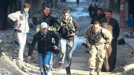 In den Straßen von Aleppo suchten diese Journalisten im Dezember vergangenen Jahres Deckung vor den Kämpfen zwischen Regierung und Rebellen. Seit Beginn des Bürgerkriegs wurden in Syrien mehr als 20 Medienmitarbeiter getötet. Foto: Muzaffar Salman/Reuters