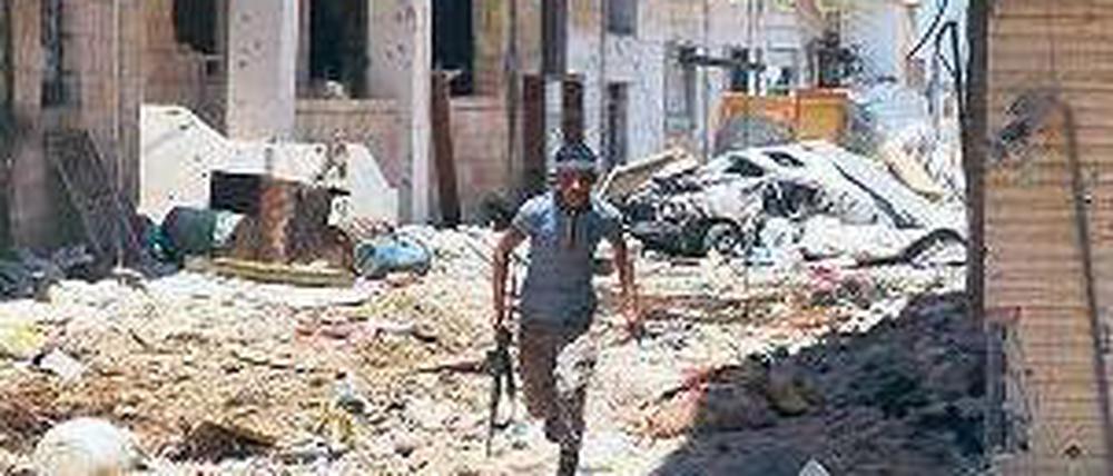 Deckung suchen. Ein Rebell in der zum Teil zerstörten Stadt Daraa. Foto: AFP