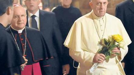 Rosen in den Farben des Vatikans für einen, der Armut predigte und lebte. Papst Franziskus in der Grabkirche des heiligten Franziskus in Assisi, begleitet von Kardinälen. Foto: dpa