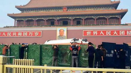 Verdeckt: Der Ort des Unfalls auf dem Platz des Himmlischen Friedens in Peking wird von Arbeitern und Polizisten abgesperrt. Auf dem Tiananmen-Platz hatten Sicherheitskräfte im Juni 1989 ein Massaker an friedlichen Demonstranten verübt. Foto: Ed Jones/AFP