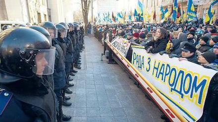Klare Fronten: Vor dem schwer bewachten Parlament in Kiew forderten Demonstranten die Absetzung der Regierung. „Das Parlament ist auf der Seite des Volkes“, steht auf dem Plakat. Doch die ukrainische Regierung überstand das Misstrauensvotum. Foto: Alexey Furman/dpa