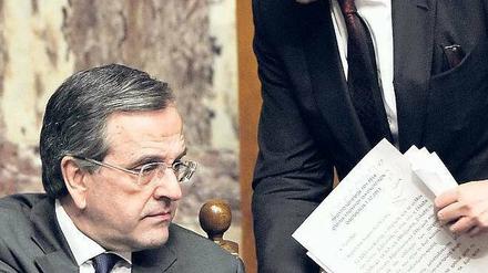 Etappensieg. Finanzminister Yiannis Stournaras (r.) und Premierminister Antonis Samaras Samstagnacht bei der Haushaltsdebatte im Parlament. Foto: Louisa Gouliamaki