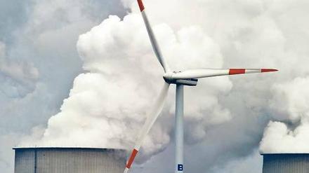 Mehr Kohle, mehr Wind. Vor dem Braunkohlekraftwerk Jänschwalde dreht sich ein Windrad. Bis Ostern soll ein Entwurf für eine EEG-Reform vorliegen. Die große Koalition will bei der Ökostromförderung schnell Fakten schaffen. 
