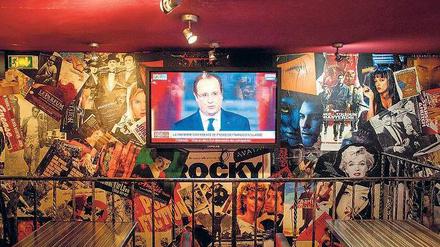 Botschaft für die Öffentlichkeit. In einer Bar in Paris läuft die Fernsehübertragung mit den wirtschaftlichen Plänen des Staatschefs François Hollande.