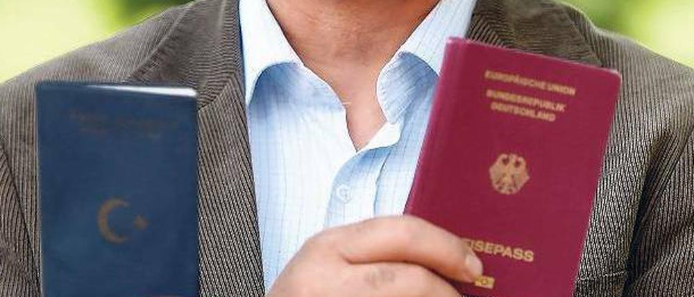 Mann zeigt seinen türkischen und seinen deutschen Pass