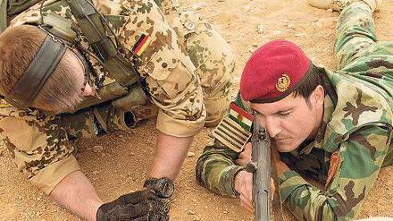 Im Sand von Erbil. Ein Soldat der Bundeswehr unterweist einen Peschmerga-Kämpfer auf einer Schießanlage in der Bedienung eines G3-Sturmgewehres. 