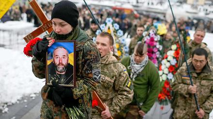 Die Tochter trägt bei der Beisetzungszeremonie in Kiew das Foto ihres Vaters Sergiy vom Bataillon "Aydar", der bei Kämpfen in der Ostukraine ums Leben gekommen war. 
