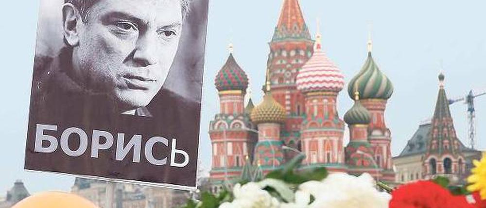 Ein Foto des Oppositionellen Boris Nemzow hängt am Tatort, wo Trauernde auch Blumen niedergelegt haben.