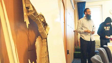 Schadensbilanz. Der IKZ-Vorsitzende Habibzada präsentiert die demolierten Türen des Kulturzentrums. 