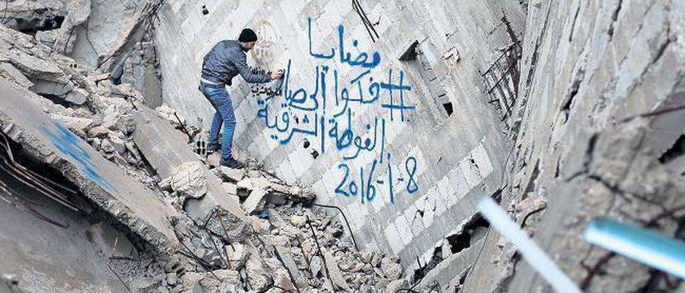 Ein Bewohner der halb zerstörten syrischen Stadt Kafr Batna protestiert mit wütenden Graffiti gegen die Belagerung von Madaja durch syrische Truppen.