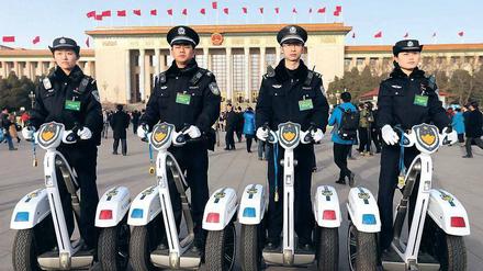 Mobile Wachposten. Chinesische Polizisten posieren vor der Großen Halle des Volkes in Peking. Foto: Wu Hong/dpa