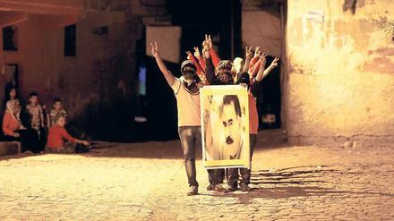 Maskierte Jugendliche mit einem Plakat, das PKK-Gründer Abdullah Öcalan zeigt.