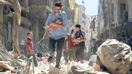 Nach dem Bombardement. Männer haben Babys geborgen und bewegen sich durch die Trümmer von Aleppo. 