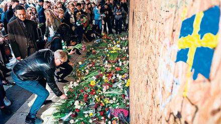 Gedenken in Schwedens Hauptstadt. Passanten legen am Tatort in der Innenstadt Blumen nieder. 