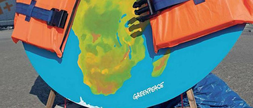 Welt mit Schwimmweste. Greenpeace ging es vor dem Brandenburger Tor nicht um ertrinkende Flüchtlinge im Mittelmeer, sondern um den Klimawandel. 