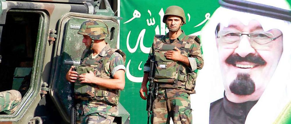Libanesische Soldaten patrouillieren vor einem Poster von König Abdullah von Saudi Arabien. 