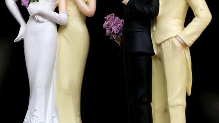 Zwei weibliche und zwei männliche Puppen in Hochzeitskleidung