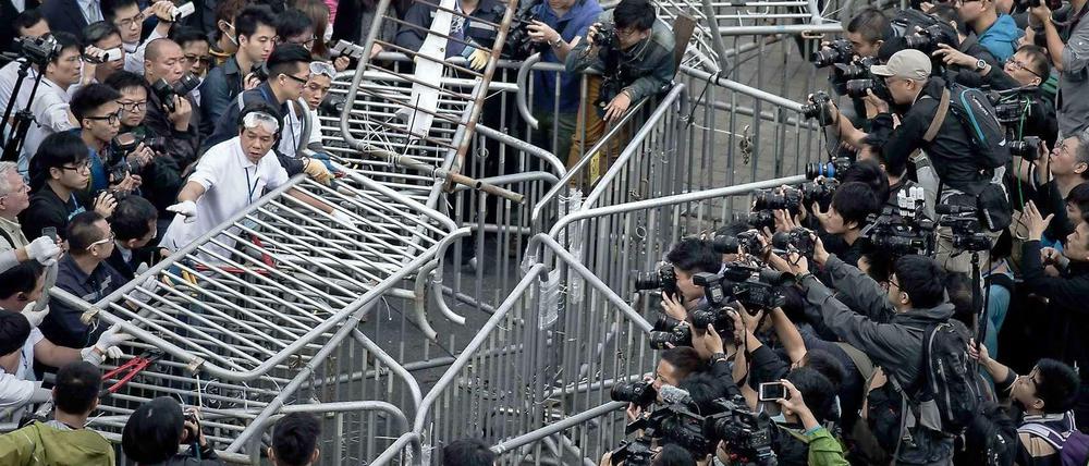 Konfrontation: Sicherheitskräfte in Hongkong bauen Barrikaden ab, Die Protestler haben noch keines ihrer Ziele erreicht.