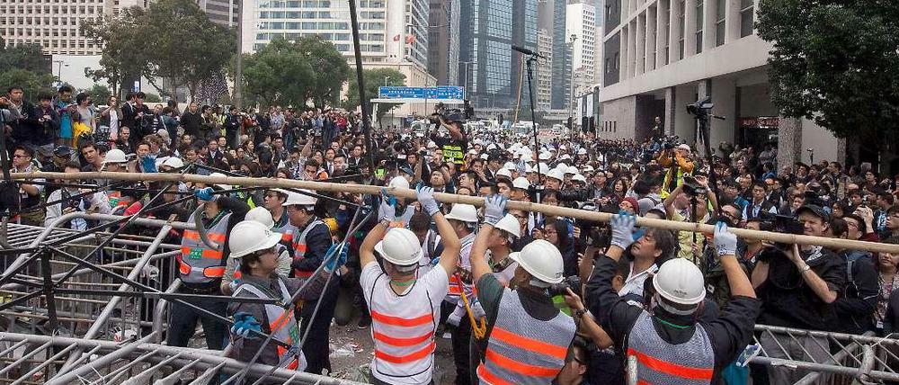 Arbeiter beginnen in Hongkong damit, die Barrikaden der Demonstranten abzubauen.