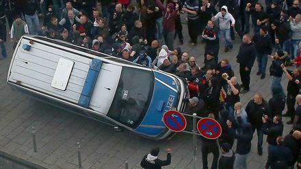 In Köln warfen die Demonstranten einen Polizeiwagen um.