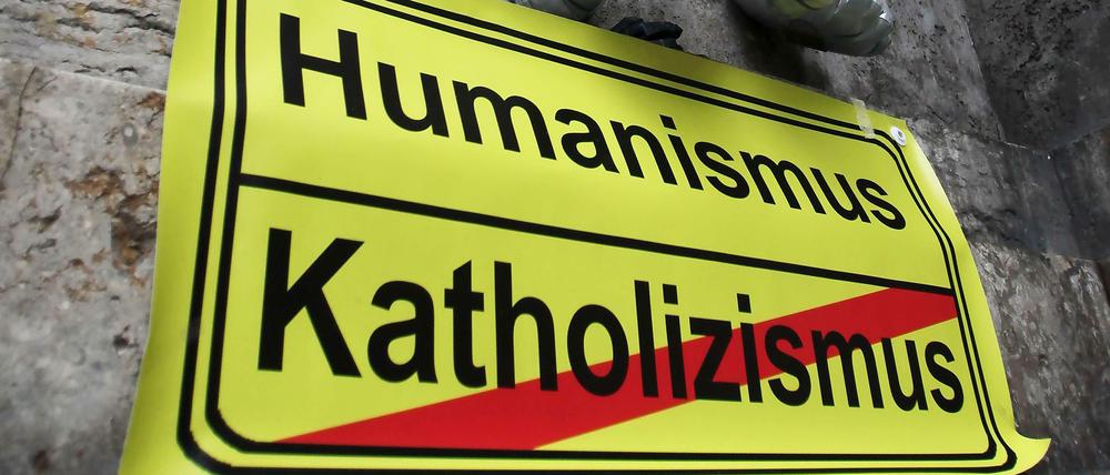 Am Rande einer Aktion kollektiver Kirchenaustritt klebte 2012 vor dem Standesamt in Mainz ein Schild mit der Aufschrift "Humanismus" und "Katholizismus (durchgestrichen).