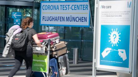 Eine Reisende gehen zum Testzentrum am Münchner Flughafen.