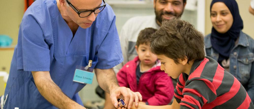 Die Gesundheitsversorgung von Asylbewerbern - hier eine syrische Familie bei der Impfung im Lageso in Berlin - ist nicht aufwendiger als bei deutschen Patienten, sagt Ärztepräsident Frank-Ulrich Montgomery.