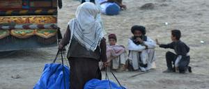 Eine Freiwillige trägt Hilfsgüter zu Menschen in einem afghanischen Dorf.