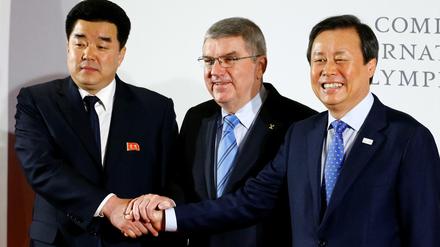 IOC-Präsident Thomas Bach besiegelt mit dem Chef des nordkoreanischen NOKs Kim Il Guk (l.) und dem südkoreanischen Sportminister Do Jong-Hwan die Teilnahme Nordkoreas an den Winterspielen 2018.