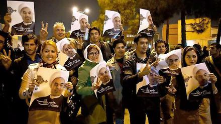 Freundlicher Empfang. Diese Menschen warteten am Flughafen in Teheran auf Irans Außenminister, als der aus Genf zurückkehrte. Sie halten Bilder von Präsident Ruhani in den Händen. 