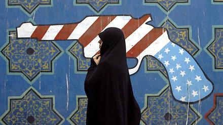 Angriffsziel Deutschland? Eine Iranerin läuft vor einer Wandmalerei, das einen Revolver in den amerikanische Nationalfarben zeigt, vorbei