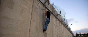 Ein Palästinenser an der umstrittenen Trennmauer in der West Bank.