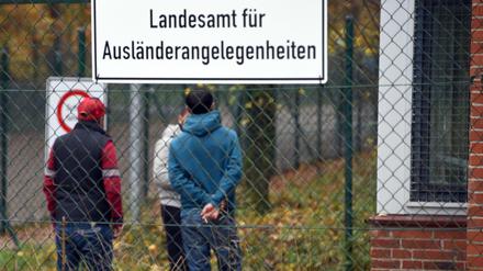 Drei junge Männer stehen in Boostedt (Schleswig-Holstein) am Zugang zu der Erstaufnahmeeinrichtung.