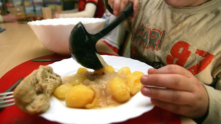 Ein Junge nimmt sich am beim Pädagogischen Mittagstisch des Kinderschutzbundes in Schwerin Soße für die Kartoffeln.