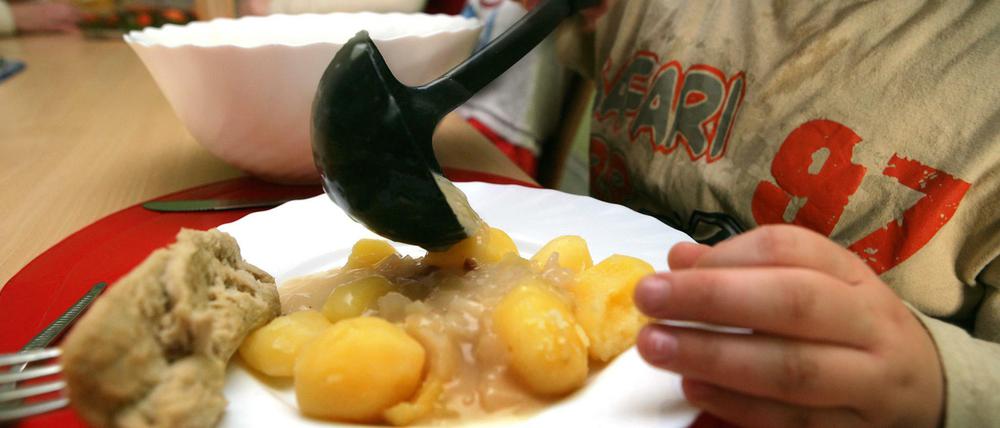 Ein Junge nimmt sich am beim Pädagogischen Mittagstisch des Kinderschutzbundes in Schwerin Soße für die Kartoffeln.