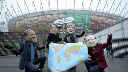 Vier Aktivisten der Entwicklungsorganisation Oxfam demonstrieren mit Pappköpfen wichtiger Staats- und Regierungschefs am Freitag vor dem Stadion in Warschau für ein besseres Klima. Tags zuvor war Oxfam mit dem WWF, Greenpeace und neun weiteren Organisationen demonstrativ aus dem Warschauer Gipfel ausgezogen. 