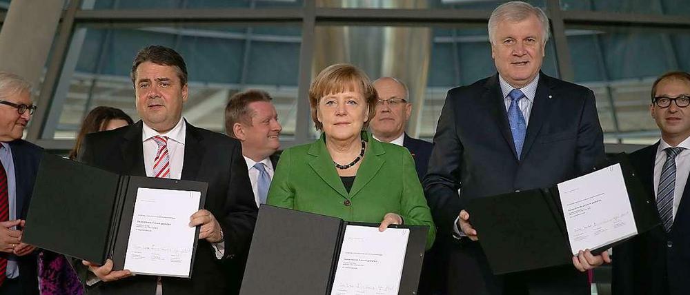 Die drei Parteichefs Merkel, Seehofer, Gabriel unterschreiben den Koalitionsvertrag - vorläufig.