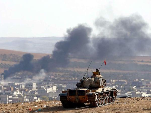 Nur Zuschauer: Ein türkischer Soldat blickt aus seinem Panzer von türkischer Seite aus auf die syrische Grenzstadt Kobane.