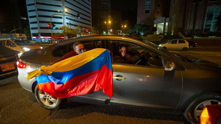 Anhänger des ehemaligen Präsidenten Uribe halten eine kolumbianische Flagge aus dem Auto und demonstrieren unter dem Motto «Wir unterstützen Uribe». Der Oberste Gerichtshof in Kolumbien hat den ehemaligen Präsidenten Uribe unter Hausarrest gestellt. 