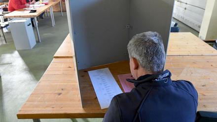 Ein Wähler sitzt bei der Stimmabgabe zur Kommunalwahl im Schleswig-Holstein im Gerätehaus der Freiwilligen Feuerwehr Homfeld.