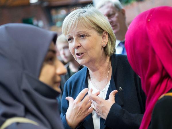 Ministerpräsidentin Hannelore Kraft (SPD) spricht am 07.09.2015 in einer Betreuungsstelle für Flüchtlinge in Dortmund (Nordrhein-Westfalen) mit zwei Helferinnen. Hier werden die Flüchtlinge nach der Ankunft am Hauptbahnhof erstversorgt. 