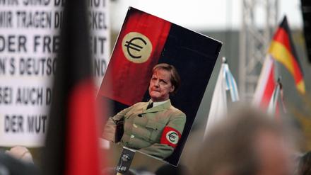 Merkel in Uniform: In Wort und Bild (hier im Oktober in Dresden) greifen die Pegida-Anhänger gern zu drastischen Vergleichen.
